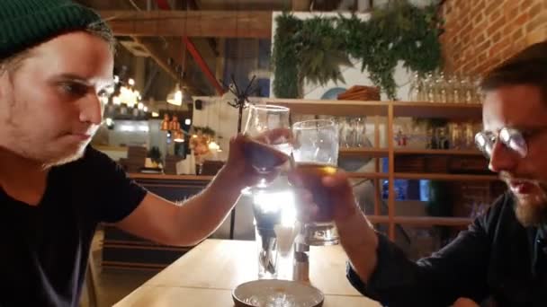 Deux types assis au bar, buvant de la bière . — Video