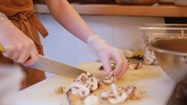 Tiro de mulher chef cortando cogumelos. Fechar — Vídeo de Stock