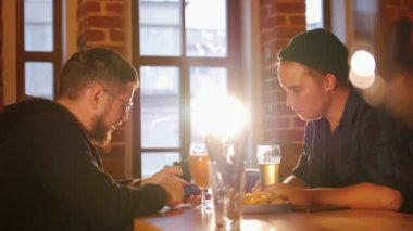 İki adam bir restoranda bir masada oturan ve bira içmek. Onlardan birini arıyorum