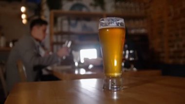 Bardaki onun arkadaşı ile konuşurken bardaklarda sakallı adam. Restoran