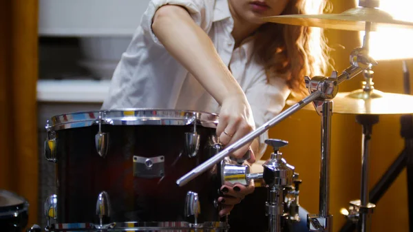 Repetição. Rapariga de gengibre toca bateria. A menina que fixa o laço — Fotografia de Stock