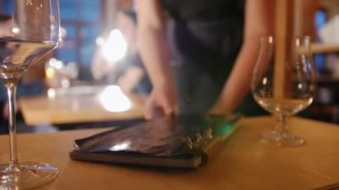 Bir garson bir menü istemcilere verir.