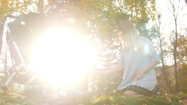 Jeune mère jouant avec son petit fils. Jouer avec les feuilles d'automne . — Video