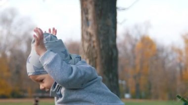 Parkta sonbahar yaprakları ile oynarken küçük bir bebek