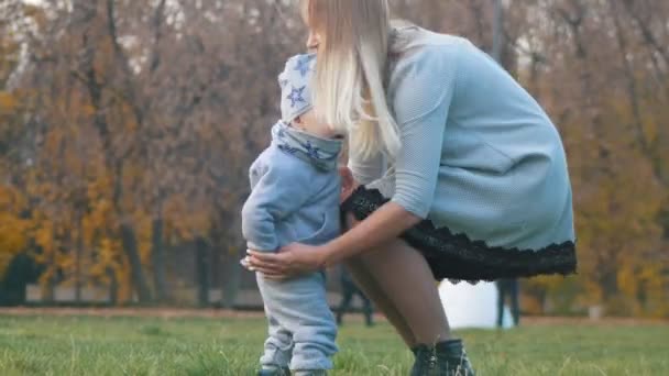 Junge Mutter hebt auf Händen ihren kleinen Sohn. glückliche Familie — Stockvideo