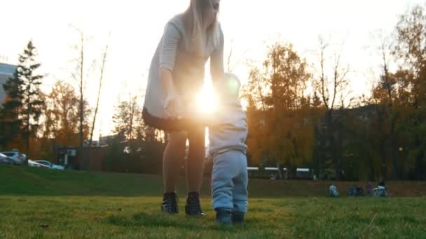 Joven Madre Levanta Las Manos Pequeño Hijo Vueltas Parque Otoño — Vídeos de Stock