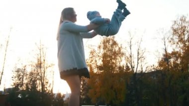 Küçük bebek oğlu ve onu iplik ellerde Genç Anne kaldırıncaya