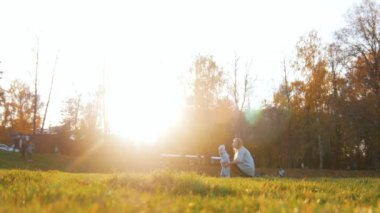 Genç Anne sunset Bulvarında sonbahar parkta yürüyen bir bebekle. Sonbahar sezon.