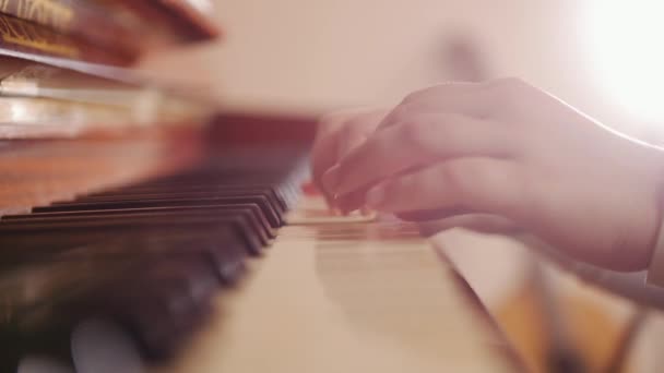 Bambino che suona il pianoforte. Vista laterale di un bambino che suona il pianoforte . — Video Stock