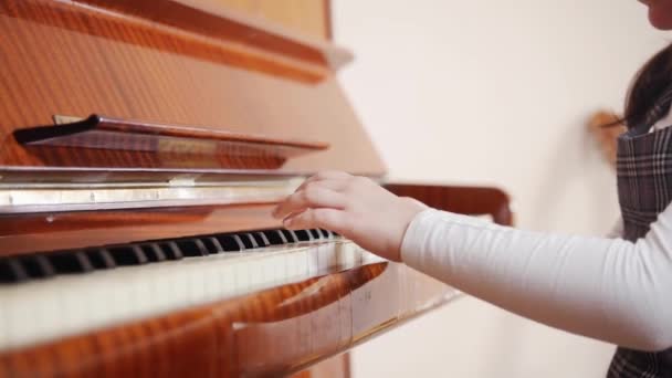 Un bambino suona il pianoforte e chiude una copertina per pianoforte — Video Stock