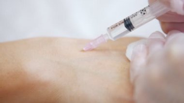 Kozmetik Kliniği. Uzman istemci kola dolgu maddeleri enjekte ediliyor. Yakın çekim