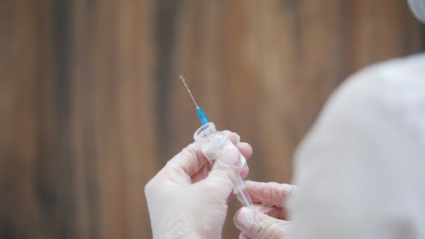 Cosmetology clinic. Syringe needle pierces the rubber stopper of the glass vial. — Stock Video