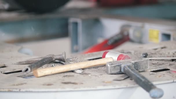 Mallet and hammer lie on the work surface against the background of flying sparks. Car repair service — Stock Video