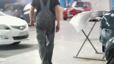 Araba tamir servisi. Tampon ve arka odak içinde belgili tanımlık makine. Backgrond büyük şişe ile yürüyen insanlar