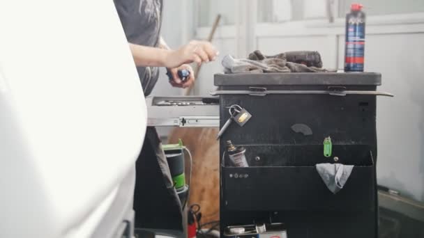Servizio di riparazione auto. Maschio lavoratore sta vicino al suo spazio di lavoro e stringerlo — Video Stock