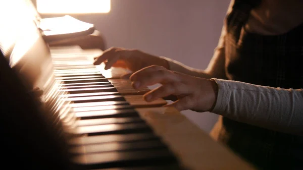 Un bambino che suona il pianoforte a lezione di musica. Bella luce del sole — Foto Stock