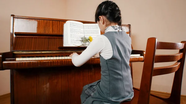 Una ragazzina che suona il piano. Vista posteriore . — Foto Stock