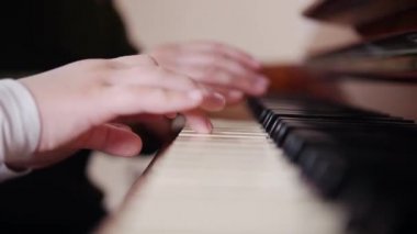 Müzik dersi. Piyano oynayan çocuk, yaşlı öğretmen yakınındaki oturur ve iskambil ile yardımcı olur. Sağ taraftan göster