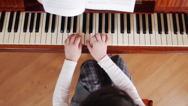 音乐课。女孩学习弹钢琴。从顶部查看 — 图库视频影像