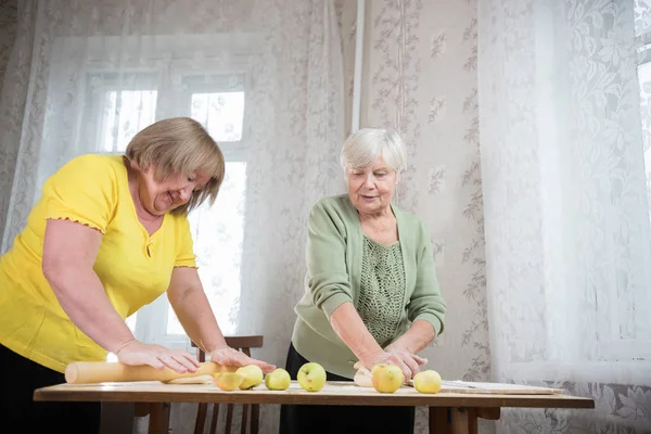 Dos ancianas haciendo pastelitos. Amasar la masa . — Foto de Stock