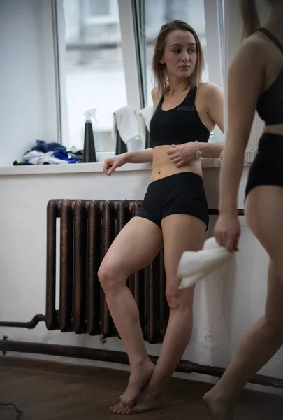 Joven mujer en forma atractiva en ropa deportiva de pie junto a la ventana —  Fotos de Stock