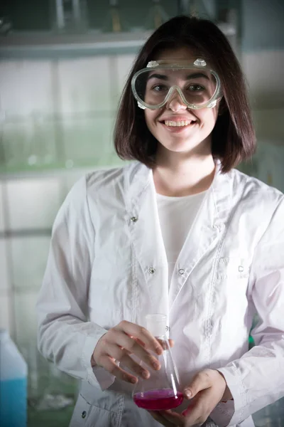 Laboratorio químico. Joven mujer sonriente en gafas de trabajo mirando a la cámara . —  Fotos de Stock