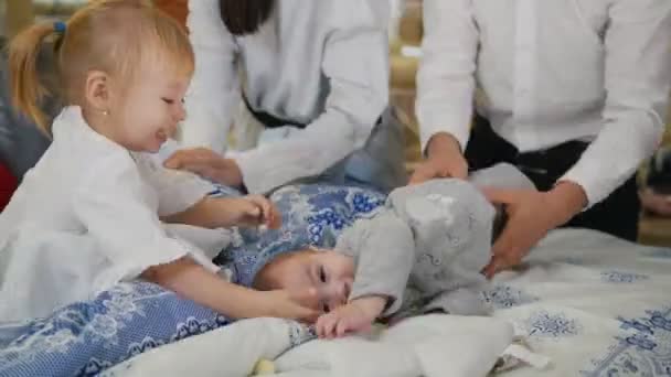 Pequeños bebés jugando en la cama en la tienda textil — Vídeos de Stock