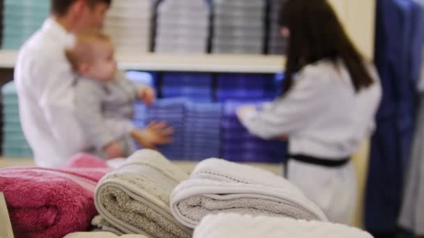 Una familia de compras. Una familia que busca albornoces y toallas de felpa — Vídeos de Stock