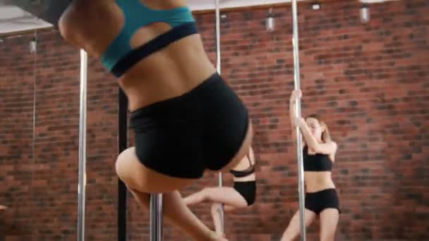 Woman trainer shows how to pole dance studio. Girls jumps up and spinning around — Stock Video