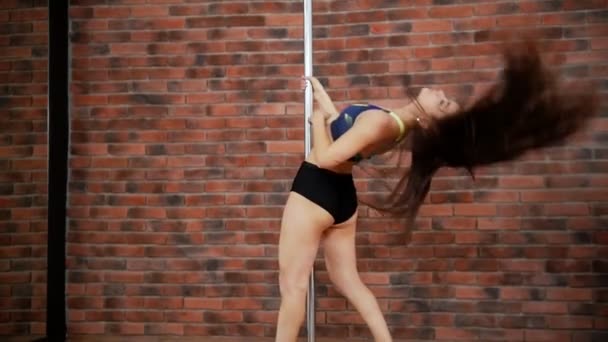 Mujer joven bailando pole dance en el estudio. Cabello volador — Vídeos de Stock