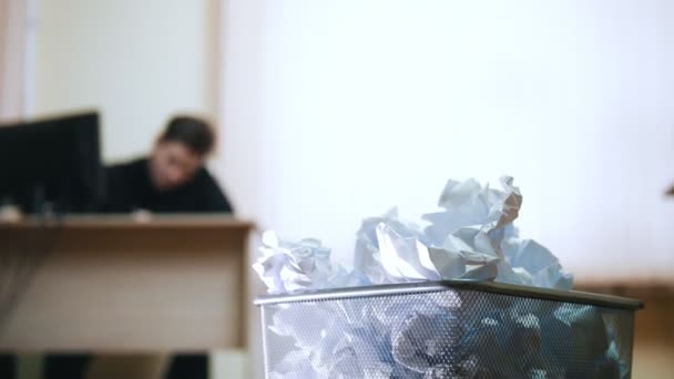 Un uomo in ufficio che scrive qualcosa, sbriciola il giornale e lo butta nella spazzatura. — Video Stock