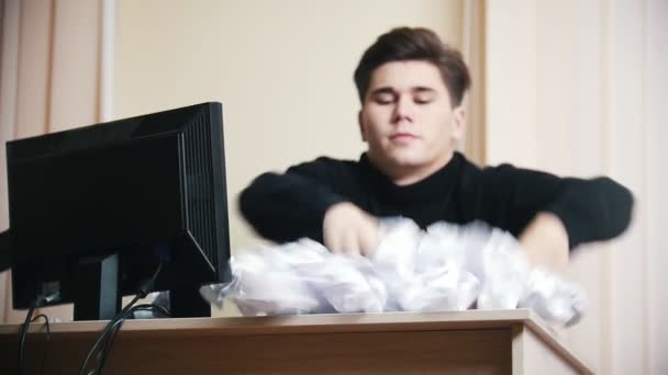 Un homme en colère jette du papier froissé loin de la table. Mouvement lent — Video