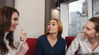 Arkadaş barda tanıştım. Üç genç gülümseyen bir kafede oturan ve konuşan kadın