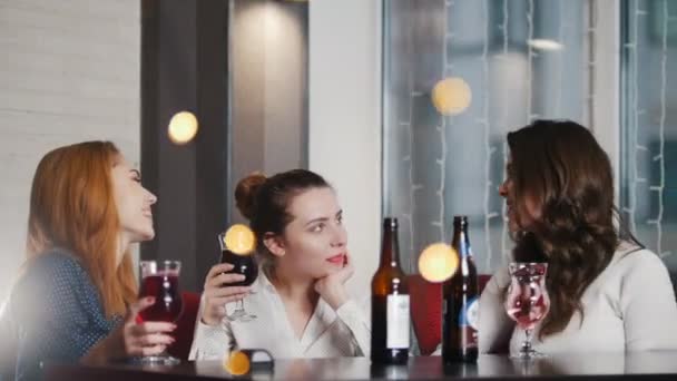 Três jovem mulher sentada no lugar do narguilé, bebendo — Vídeo de Stock