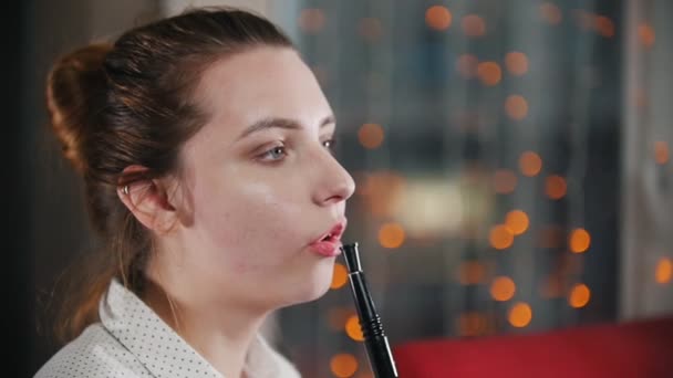 Una chica guapa en un bar fumando una cachimba. Soplando círculos de humo. Retrato — Vídeos de Stock