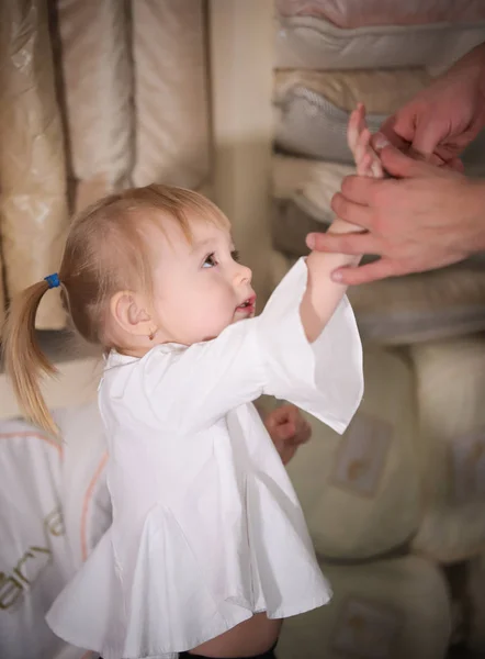 在纺织商店的小快乐的金发碧眼的女婴 — 图库照片