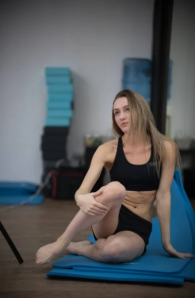 Jovencita rubia en clase de yoga posando. Un estilo de vida saludable en el gimnasio. Estiramiento —  Fotos de Stock