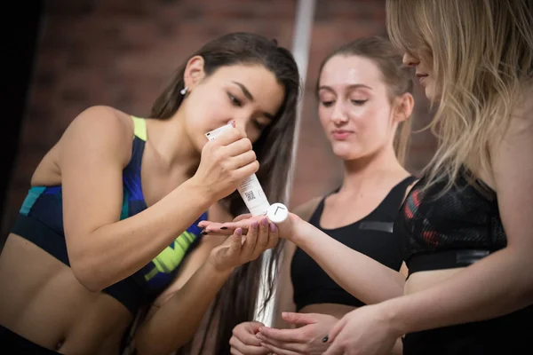 Mujer joven lubrica bailarinas manos con crema —  Fotos de Stock