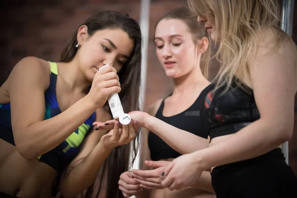 Tres mujeres jóvenes lubrican las manos de las bailarinas con crema —  Fotos de Stock