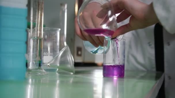 Laboratorio químico. Mujer joven haciendo un experimento, líquido cambiando de color — Vídeo de stock
