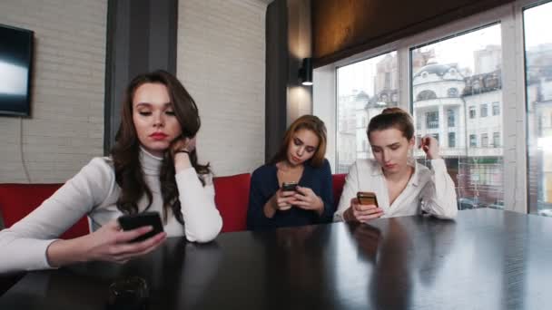 Drie jonge mooie vrouw in de plaats van de waterpijp zitten op hun telefoons. — Stockvideo