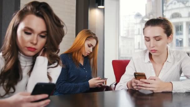 Drie jonge mooie vrouw in de plaats van de waterpijp zitten op hun telefoons in stilte — Stockvideo