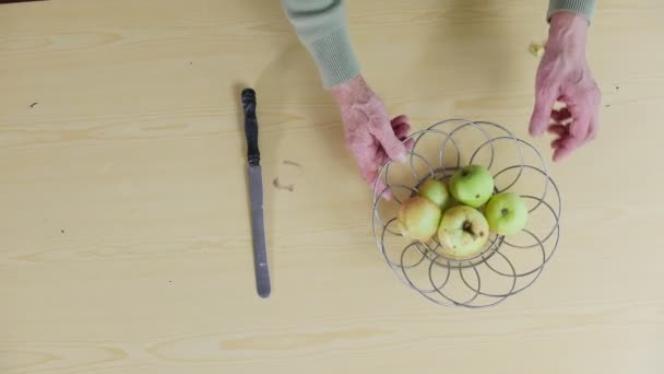 Uma velha servindo um prato com maçãs — Vídeo de Stock