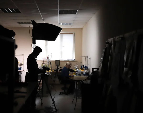 Nos bastidores das filmagens da fábrica de roupas. Sílhueta do operador — Fotografia de Stock