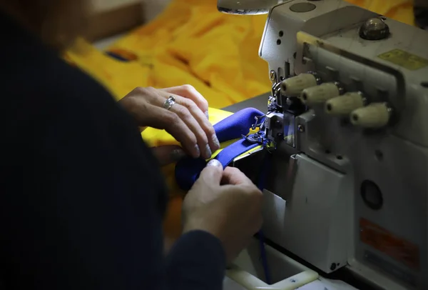 Uma mulher trabalhando com uma máquina de costura . — Fotografia de Stock