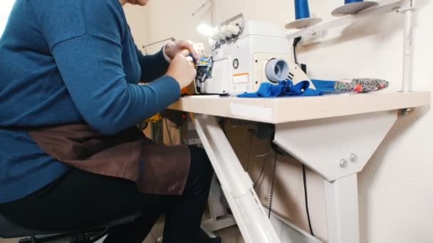 Mujer madura trabajando con máquina de coser en fábrica — Vídeos de Stock