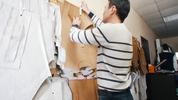 Usine de couture. Un homme qui prend des gabarits du mur. Gros plan — Video