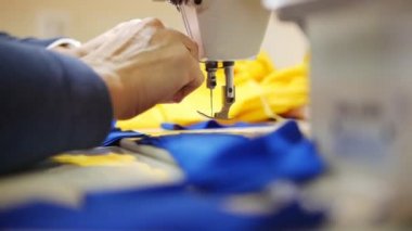 Kadın ile tekstil dikiş makinesi üzerinde çalışıyor. Kumaş üzerinde odaklanmak