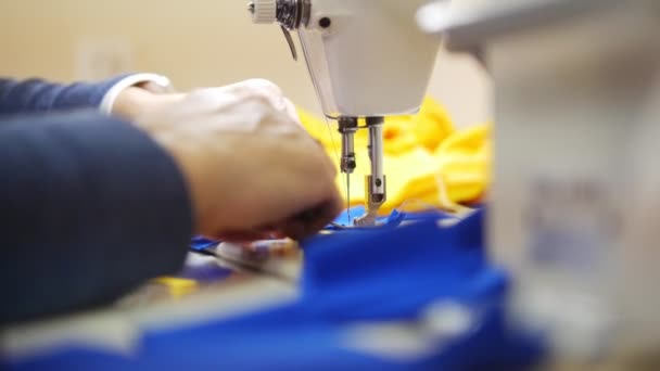 Vrouw werkt met doek op de naaimachine. Focus op textiel — Stockvideo