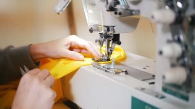 Giysi yapma. Kadın dikiş makinesi üzerinde çalışıyor. 4k vurdu